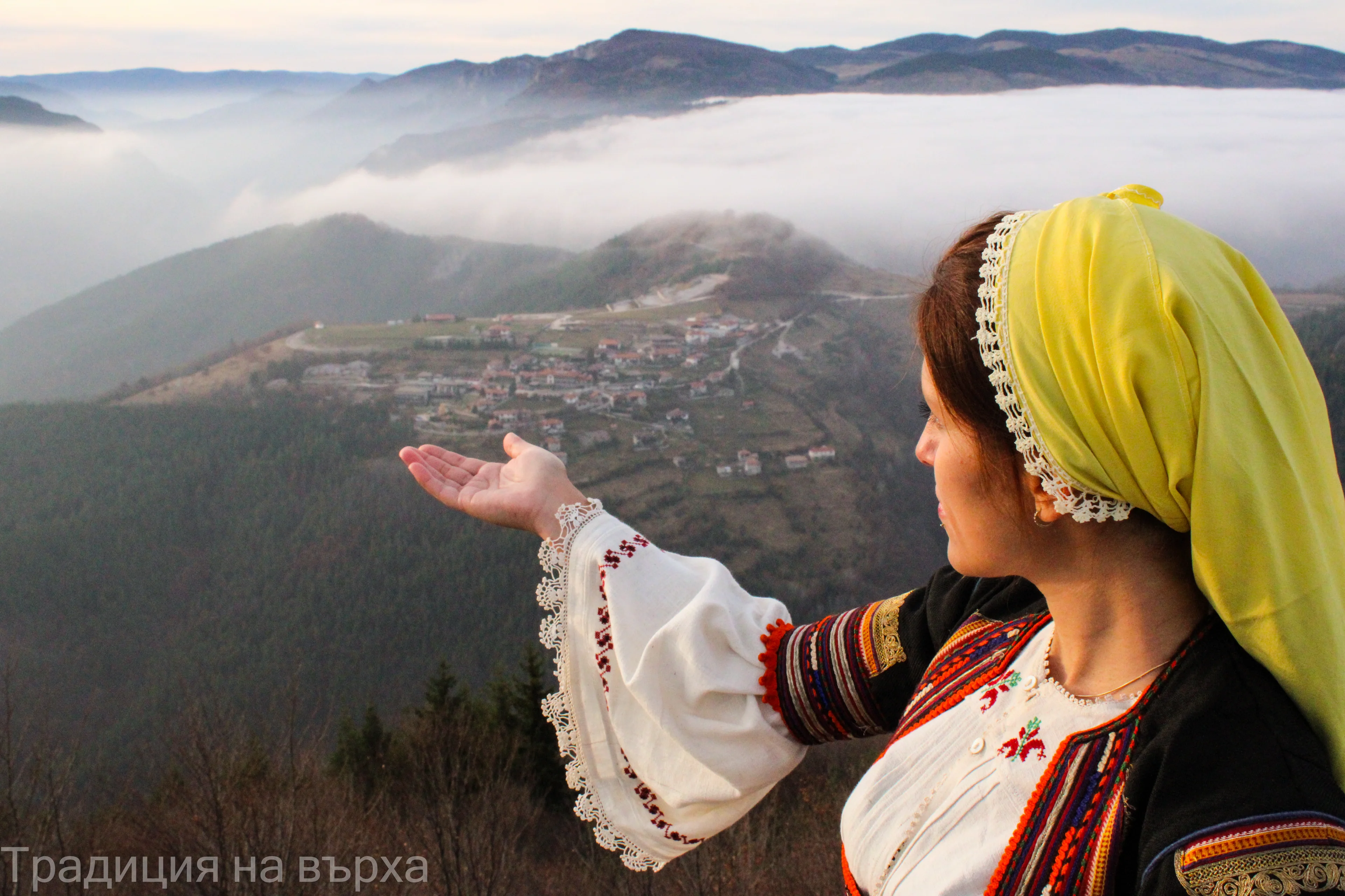 A woman in traditional dress overlooking the mountains