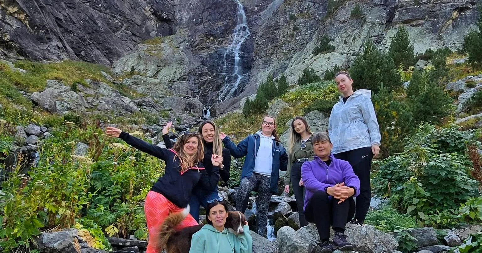 A hiking group beside a waterfall